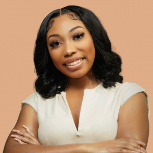 Kayla Waters smiling at the camera. Peach colored background